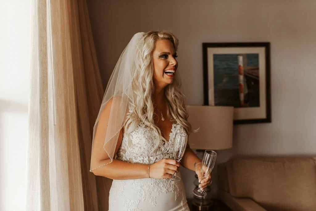 Real Bride Morgan wearing Stella York Style 6648 holding champagne glasses