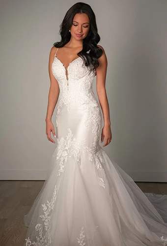 Bride wearing lace fit-and-flare wedding gown with thin spaghetti straps
