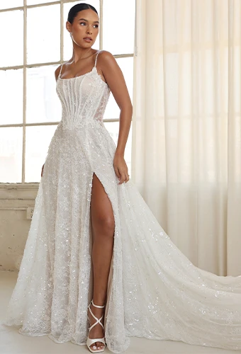 Bride wearing vintage-inspired sparkling art deco lace wedding dress with high leg slit and spaghetti straps