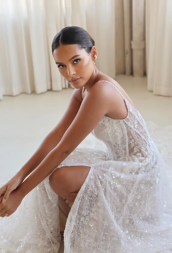 Bride crouching down wearing vintage-inspired wedding dress with sparkling art deco lace