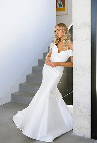 bride leaning on wall with hands clasped wearing Martina Liana 1486