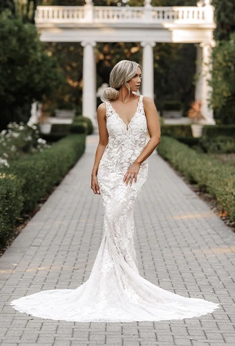 Bride wearing vintage lace wedding dress with v-neckline in garden