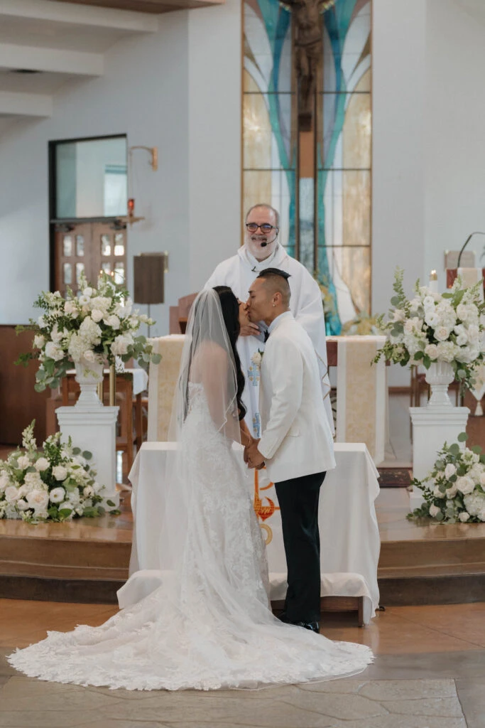 real bride angie kissing husband on the altar after ceremony wearing 1367 by Martina Liana