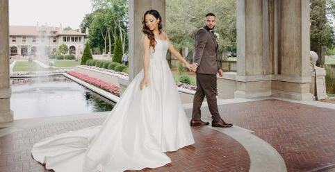 real bride olivia holding husbands hand in pavilion - style 7711 by Stella York
