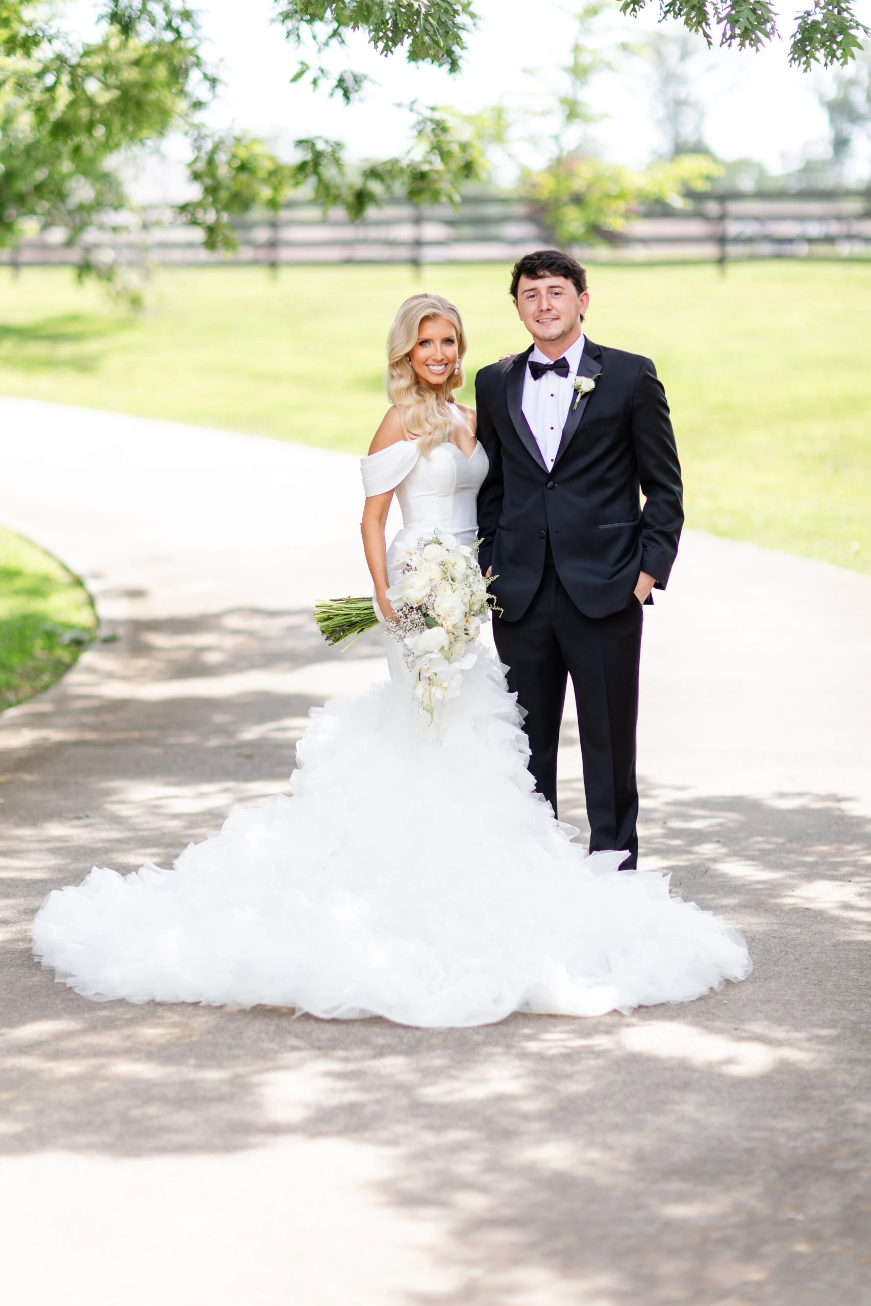 real bride Jadah posing on dirt path with husband wearing 1611 by Martina Liana