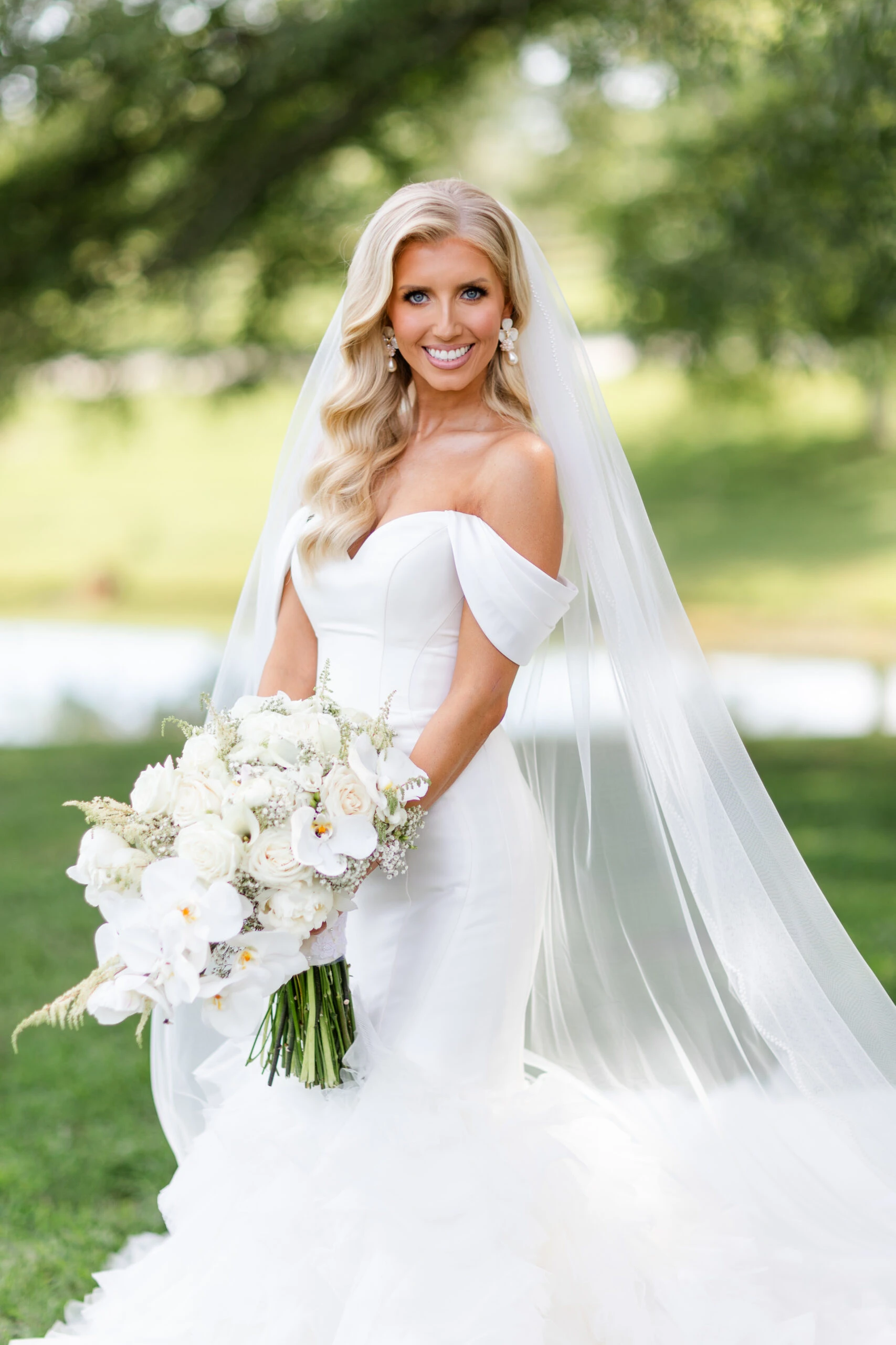 real bride Jadah smiling and holding bouquet while wearing 1611 by Martina Liana
