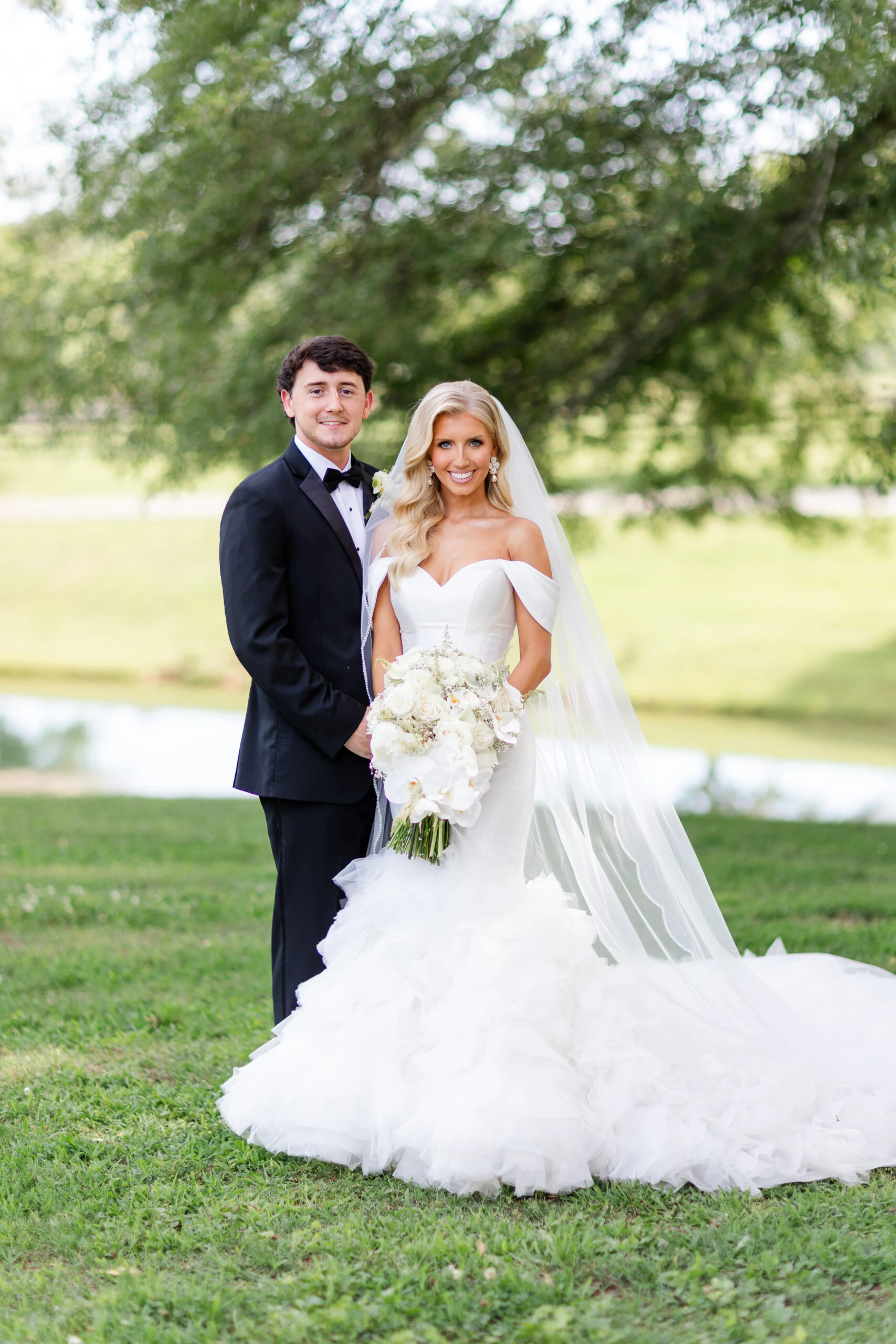 real bride jadah posing in a field with husband and bouquet - 1611 by Martina Liana