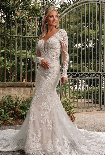 Bride wearing lac wedding dress with long sleeves and plunging neckline