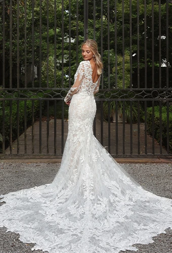Bride wearing vintage-inspired lace wedding dress with long sleeves and long lace train