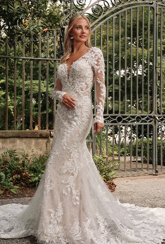 Bride wearing vintage-inspired lace wedding dress with long sleeves and plunging deep v-neckline