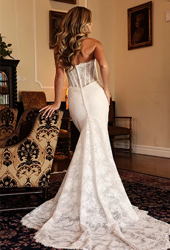 Bride wearing strapless lace mermaid wedding dress with fabric covered buttons