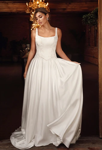 Bride wearing satin ballgown wedding dress with square neckline and beaded lace