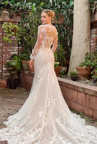 Bride wearing lace wedding dress with sheer back and long sleeves