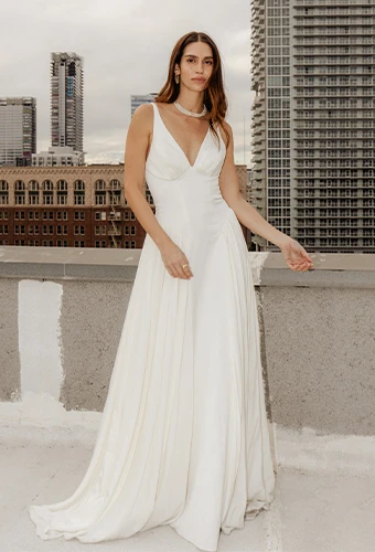 Bride wearing simple a-line wedding dress with drop waist and shoulder straps