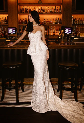 Bride wearing lace strapless mermaid wedding dress with peplum waist