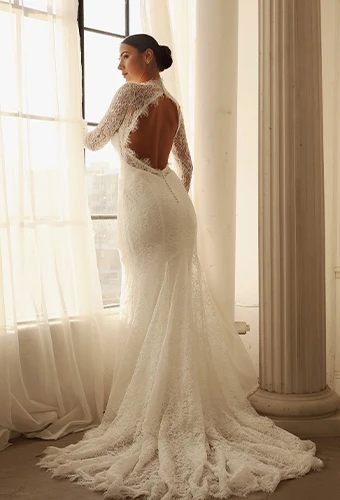 Bride wearing vintage lace wedding dress with long sleeves and open back