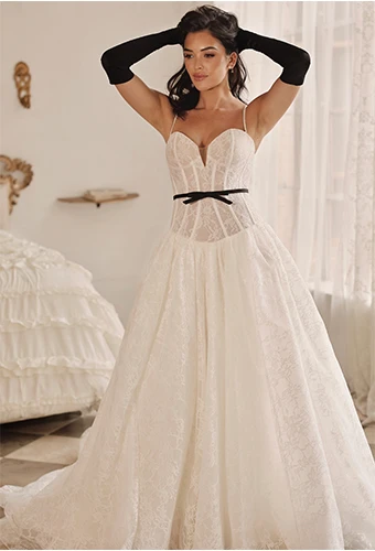 Bride wearing lace drop waist wedding dress with detachable bow belt