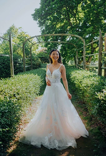 bride posing in a garden wearing Stella York style 7492 