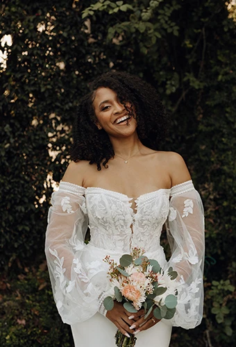 bride holding bouquet wearing off the shoulder mermaid gown - 7675 by Stella York