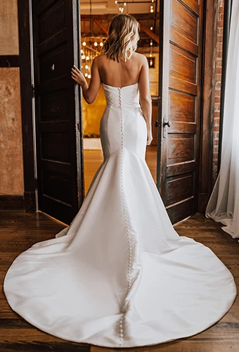 Bride wearing strapless wedding dress with fabric-covered buttons