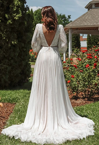 Bride wearing a-line wedding dress with long blouson sleeves and open v back