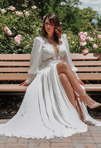 Bride wearing long-sleeve wedding dress with lace, v-neckline and high leg slit