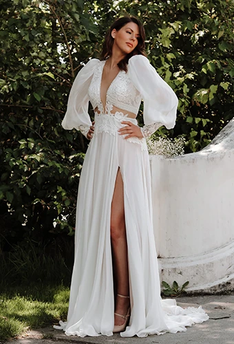 Bride wearing long-sleeve wedding dress with lace, v-neckline and high leg slit