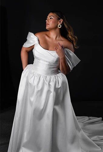 Plus size bride wearing a- line wedding dress with off-the-shoulder sleeves
