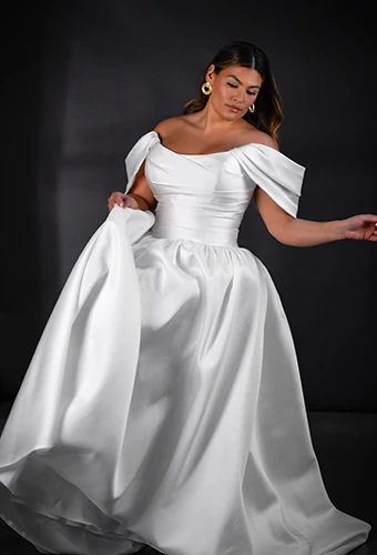 Plus size bride wearing a- line wedding dress with off-the-shoulder sleeves