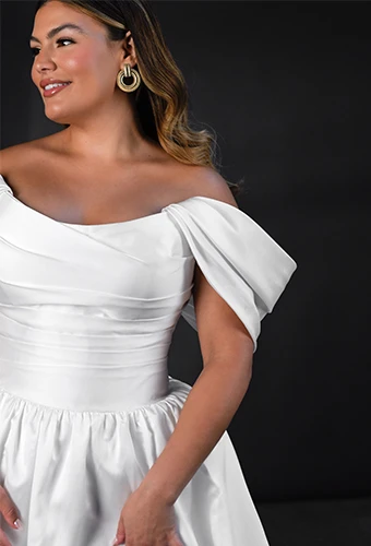 Plus size bride wearing a- line wedding dress with off-the-shoulder sleeves