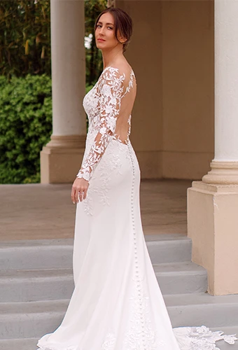 Bride wearing long sleeve illusion lace wedding dress with keyhole open back and fabric-covered buttons