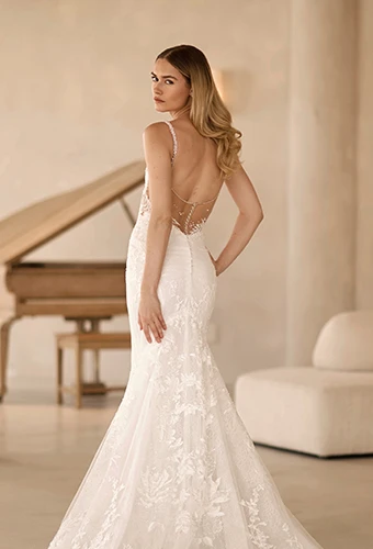 Bride wearing lace fit-and-flare wedding dress with open back