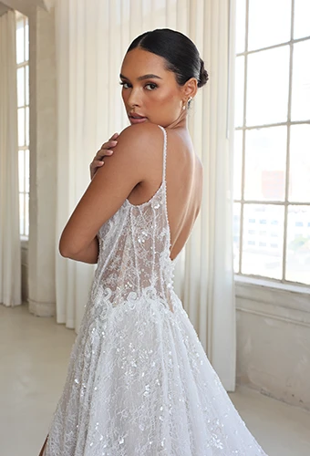 Bride wearing sparkling lace wedding dress with sheer sides and plunging v back