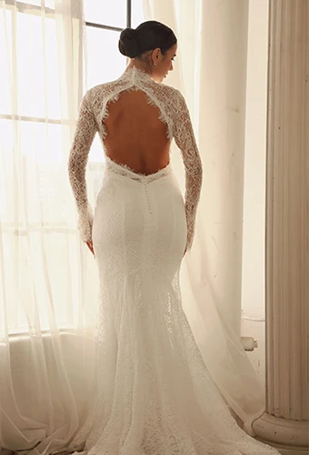 Bride wearing lace long sleeved wedding dress with keyhole open back
