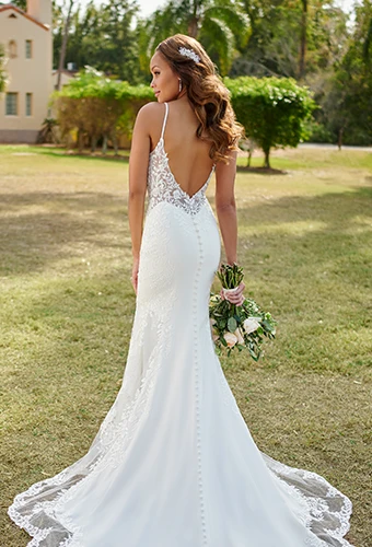 Bride wearing lace wedding dress with low v back and fabric-covered buttons