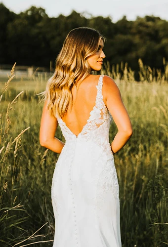 Bride wearing lace wedding dress with straps and low v open back