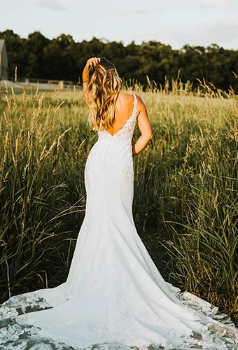 Bride wearing lace wedding dress with straps and low v open back
