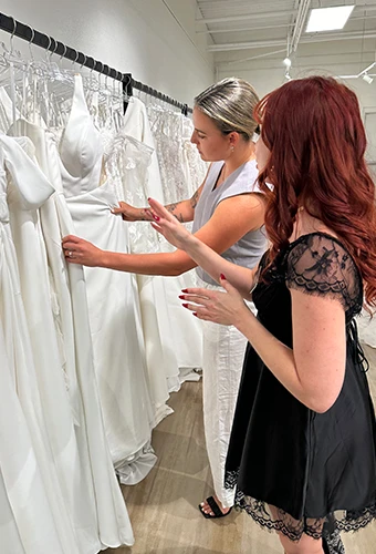 Bride and bridal stylist picking a wedding dress