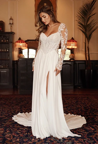 Bride wearing chiffon wedding dress with long lace sleeves and high leg slight