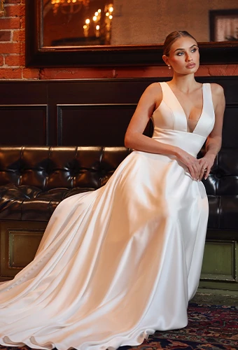 Bride wearing sating wedding dress with deep V-neckline.