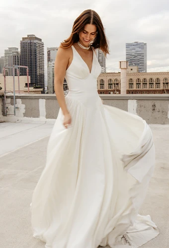 Bride wearing simple chiffon wedding dress with v-neckline and shoulder straps