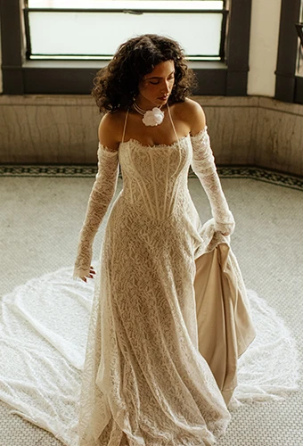 Bride wearing lace strapless wedding gown with long sleeves