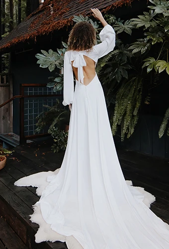 Bride wearing chiffon wedding dress with long sleeves and open back