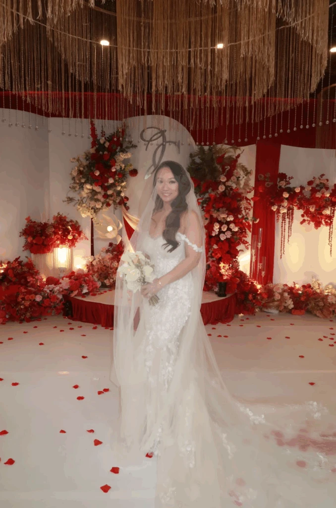 Real bride Christine posing in her wedding gown with a romantic floral background