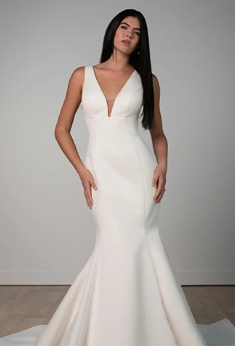 Bride wearing simple fit-and-flare wedding dress with v-neckline and shoulder straps