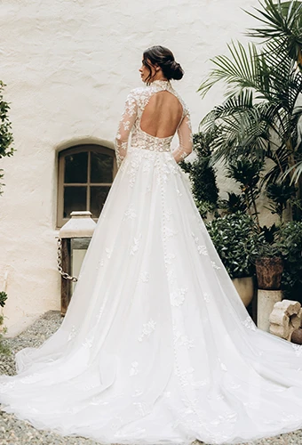 Bride wearing lace wedding dress with open keyhole back and long sleeves