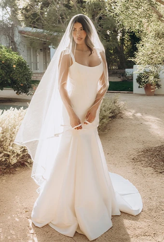 Bride wearing fit-and-flare wedding dress with veil and scoop neckline