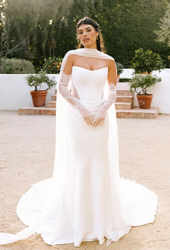 Bride wearing strapless wedding dress with side cutouts and optional sleeves