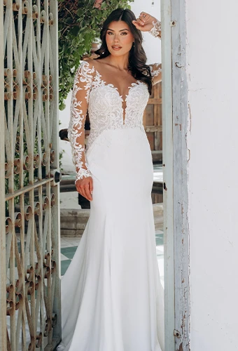 Bride wearing long sleeve wedding dress with plunging neckline and lace