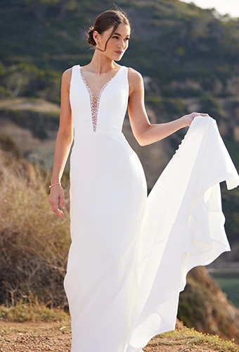 Bride wearing minimalist wedding dress with plunging neckline and beaded details